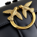Close-up of gold love-birds buckle engraved with PINKO on Pinko Love Mini Bag in black leather