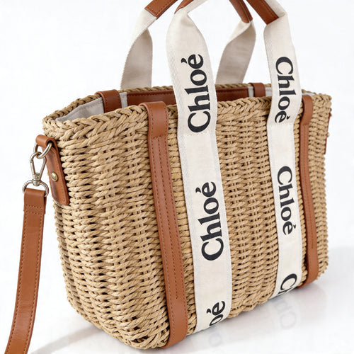 Chloé Woody Basket Tote, close-up showing woven Chloé wordmark on cotton canvas straps and tan leather corner reinforcements