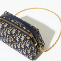 Christian Dior Bobby Bag, navy Oblique canvas, 3/4 front view, gold chain strap extended, off-white background