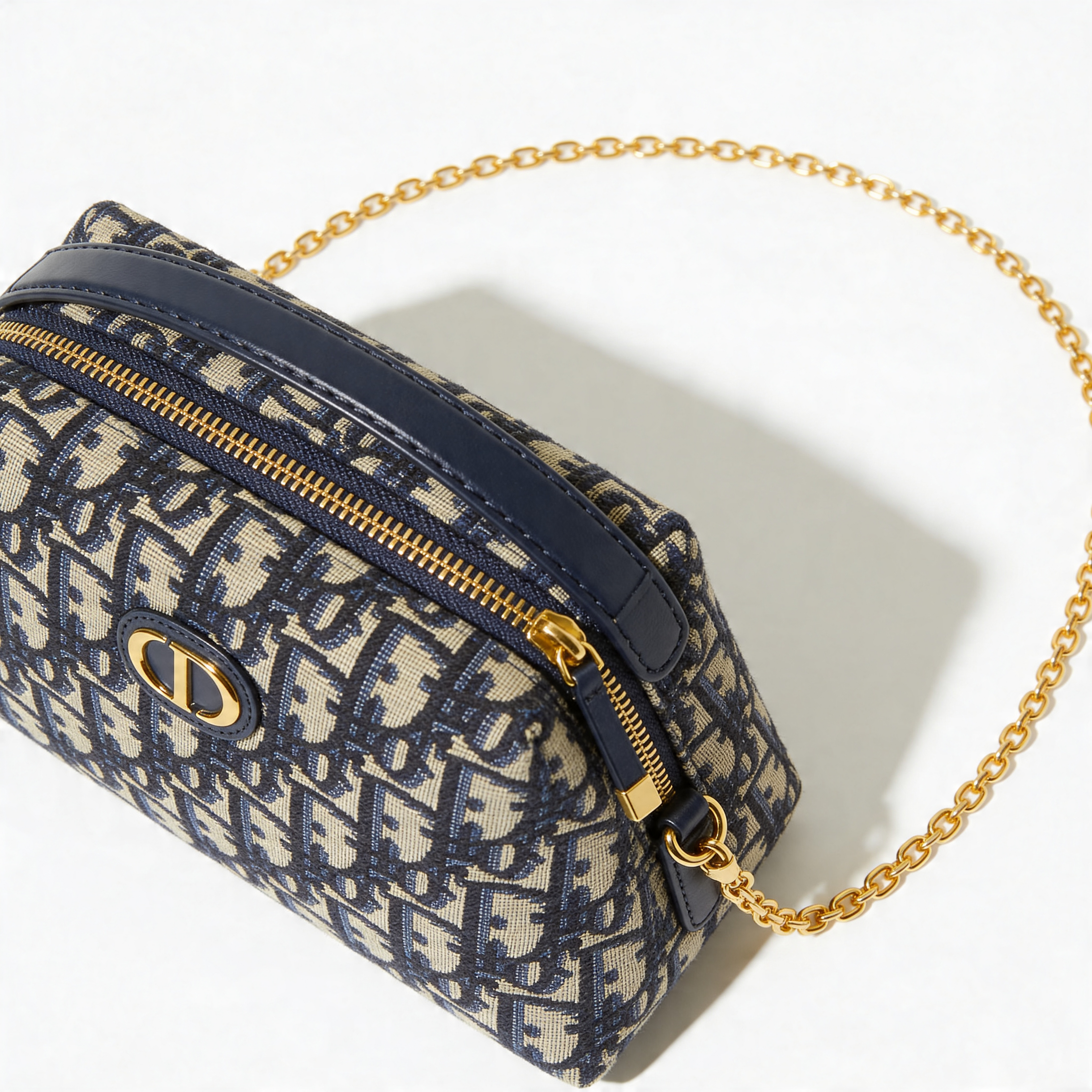 Christian Dior Bobby Bag, navy Oblique canvas, 3/4 front view, gold chain strap extended, off-white background
