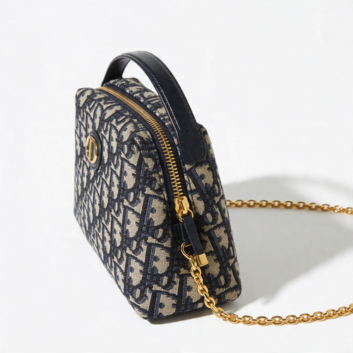 Christian Dior Bobby Bag, navy Oblique canvas, side profile with top handle, gold chain strap, off-white background