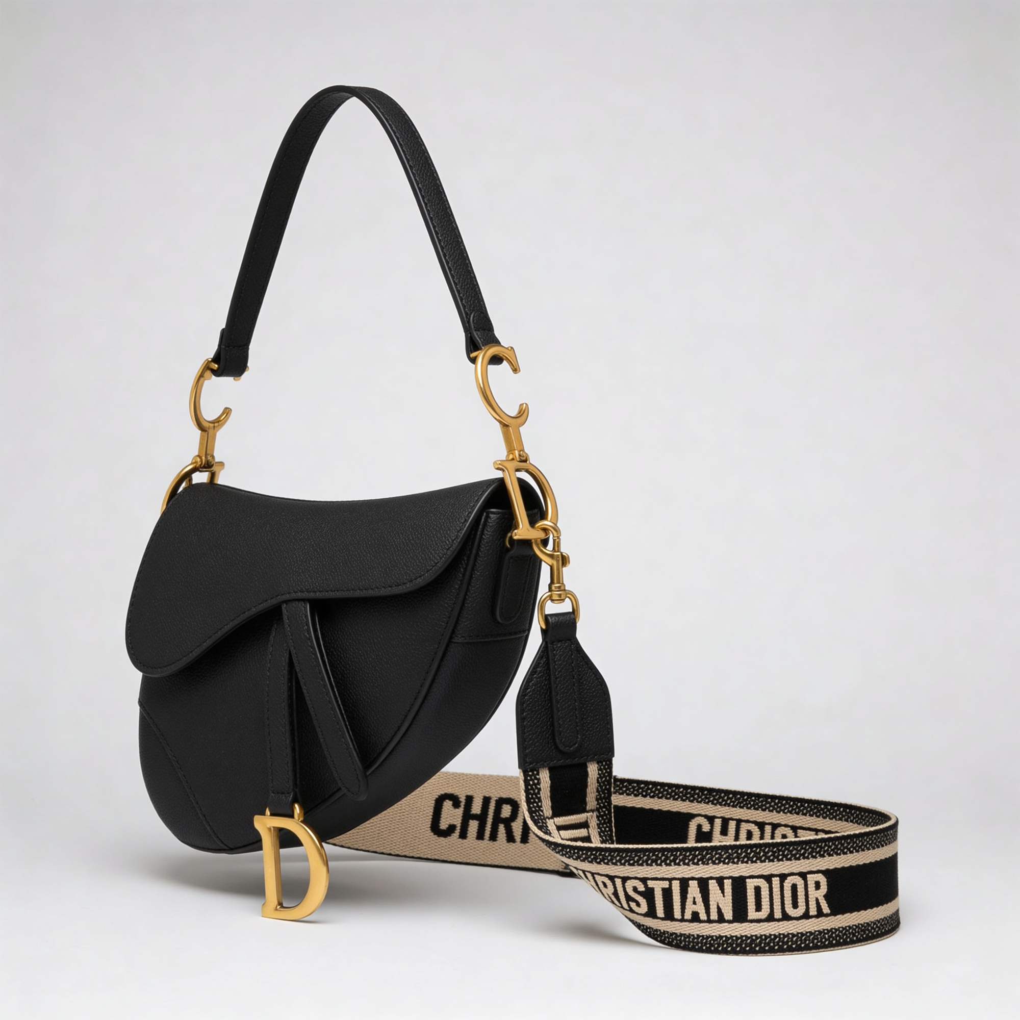 Christian Dior Saddle Bag, black grained leather, gold D charm and embroidered Christian Dior shoulder strap, side angle